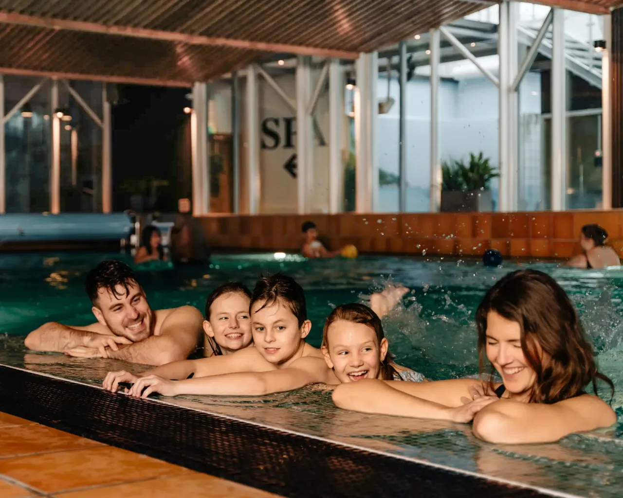 Familj som njuter av inomhuspool på spa på Bohusgården hotell vid havet på västkusten